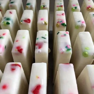 a close up of a tray of white chocolate with colorful sprinkles