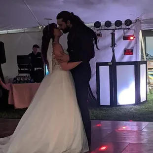 Bride and groom&apos;s first dance with the DJ booth in the background.