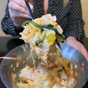 a woman holding a fork full of food