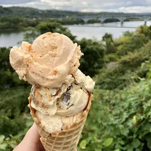 a hand holding a cone of ice cream