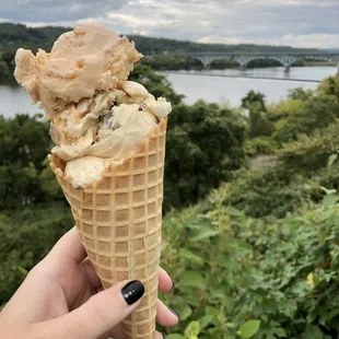 a hand holding a cone of ice cream