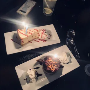 two plates of desserts with a lit candle