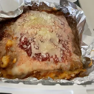 Lasagna filling a plate lunch container