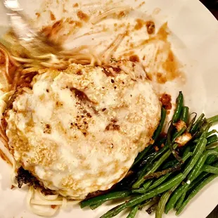 Chicken parmigiana over pasta with marinara and a side of sautéed green beans.