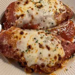 two chicken parmesan on a white plate