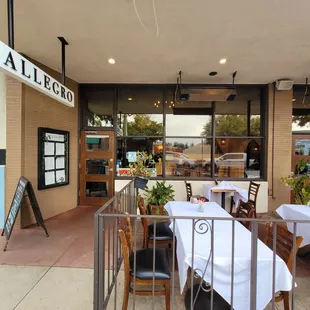 the outside of a restaurant with tables and chairs