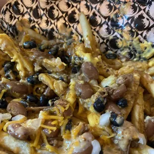 a bowl of fries with black beans and cheese