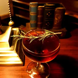 a glass with a sprig of rosemary