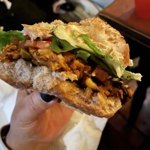 a hand holding a sandwich