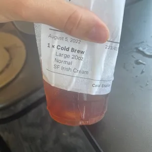 a hand holding a cup of cold brew