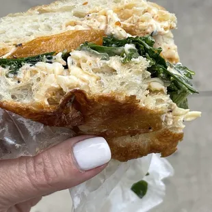 a hand holding a sandwich