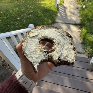 A pumpernickel bagel with broccoli and cheddar schmear