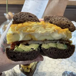 Egg and cheese sandwich on pumpernickel with latke hash brown and avocado