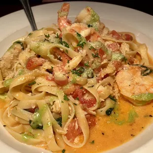 a plate of pasta with shrimp and vegetables
