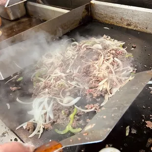 Piles of fresh sliced steak with grilled onions and green peppers.   So legit!