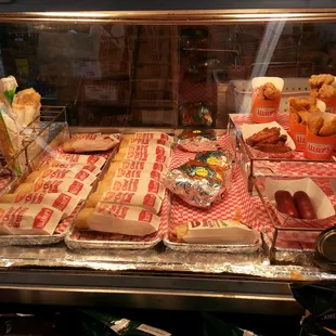 a display of hot dogs and other foods