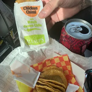 a person holding a bag of chips
