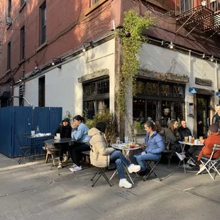 a group of people sitting outside of a restaurant