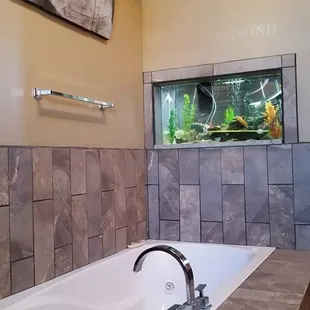 MODERN IN WALL FISH TANK DESIGN INTO MASTER BATH JETTED TUB