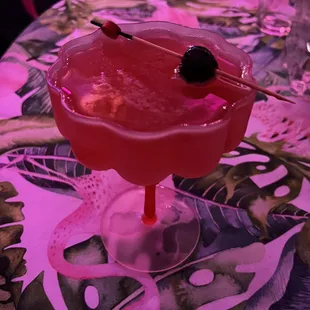 a pink cocktail with a cherry garnish