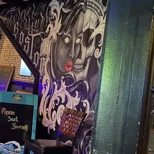 a mural of a woman with a skull on her face