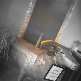 a cow statue with a mirror in the background