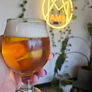 a hand holding a glass of beer