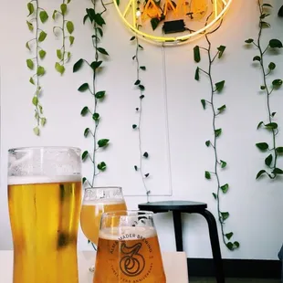 two glasses of beer and a neon sign