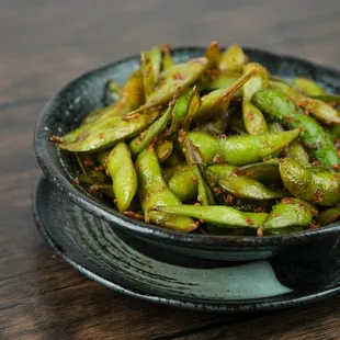 Unleash your taste buds with our Spicy Garlic Edamame!  A fiery twist on a classic favorite.