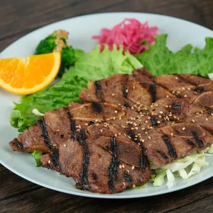 Experience the sizzling delight of our Kalbi!  Tender marinated beef grilled to perfection.