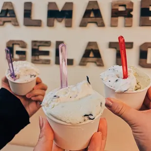 three people holding cups of gelato