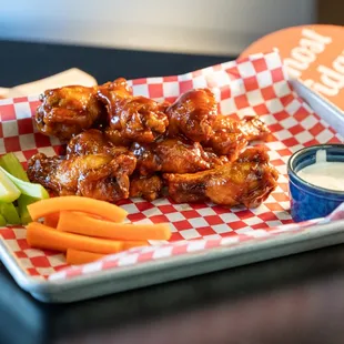 a tray of chicken wings and carrots