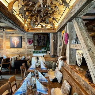 a rustic dining room with antlers on the ceiling
