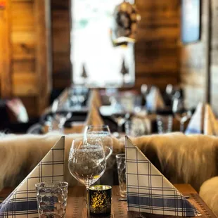 a table setting with wine glasses and napkins