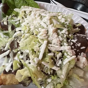 Molotes. Fried masa stuffed with chorizo and potatoes.  Topped with black beans and cheese.   Loved it.