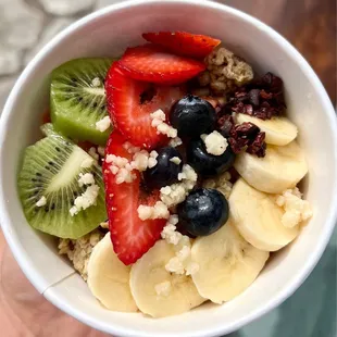Lilikoi bowl -- kiwi, banana, mac nuts, blueberries, cocoa nibs, strawberries, granola, agave over a lilikoi base