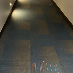 Misc crumbs/a wrapper strewn along the hallway floor.