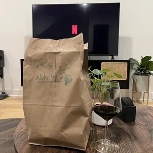 a glass of wine and a paper bag