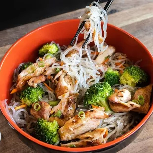a bowl of noodles with chicken and broccoli