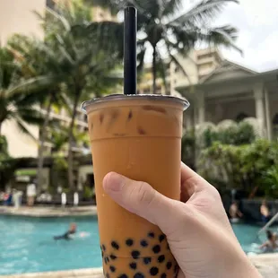 a hand holding a cup of bubble tea