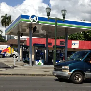a gas station with a blue and green sign