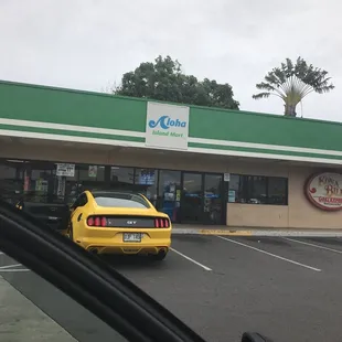 a yellow car parked in front of a gas station