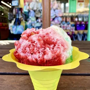 Rainbow flavored shave ice with one scoop of ice cream
