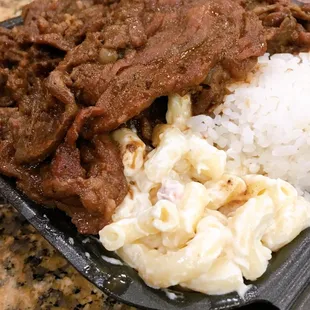 BBQ beef with white rice and macaroni salad. cabbage hiding underneath