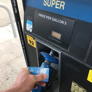 a person filling gas into a gas pump