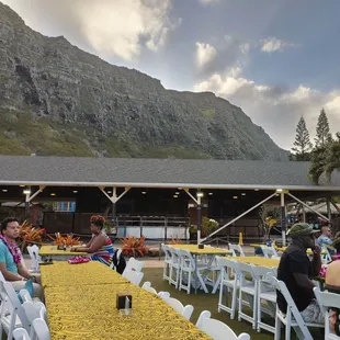 a group of people sitting at a table with a mountain in the background