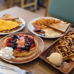 Fruity soufflé pancake, waffles with ice cream, sausage with potatoes and omelette.