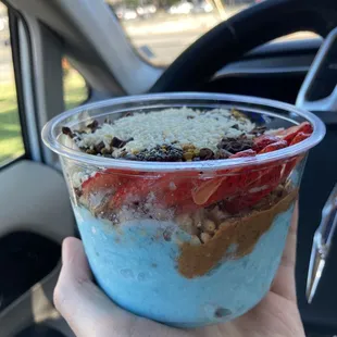 a hand holding a cup of yogurt