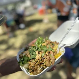 a person holding a container of food