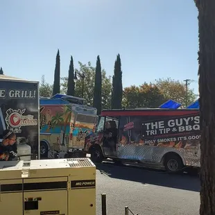 a food truck parked next to a tree